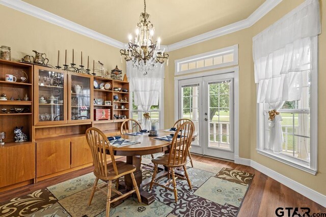 dining room featuring crown molding, an inviting chandelier, light wood-style flooring, and baseboards