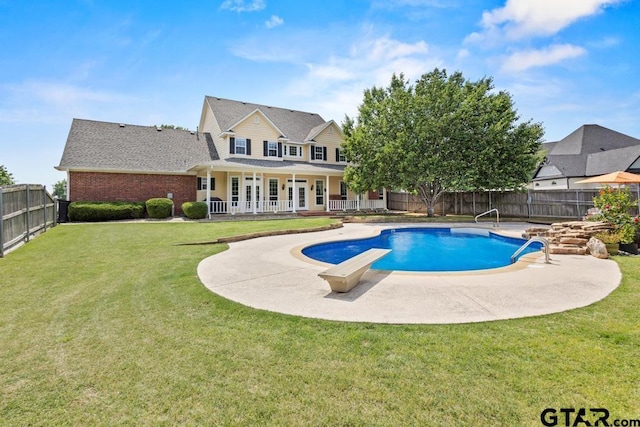 view of swimming pool featuring a fenced backyard, a diving board, a yard, a fenced in pool, and a patio area