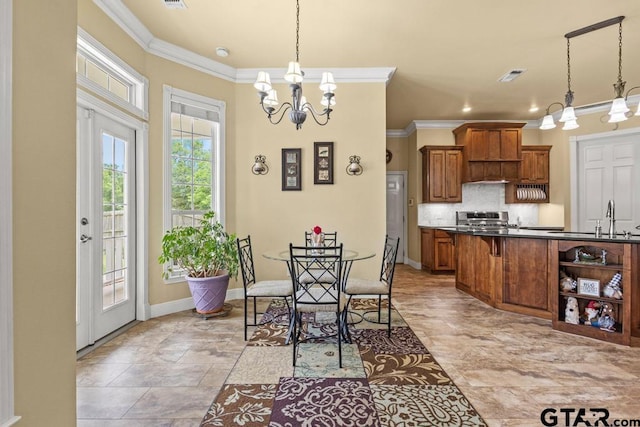 dining space featuring baseboards, visible vents, ornamental molding, and an inviting chandelier