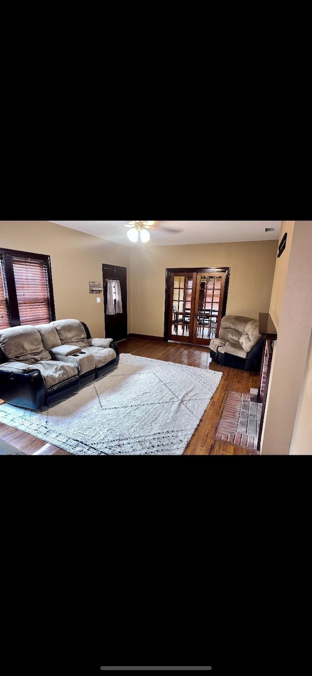 living room with wood finished floors and a ceiling fan