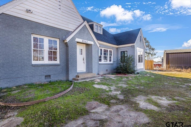 view of front of house featuring brick siding and crawl space