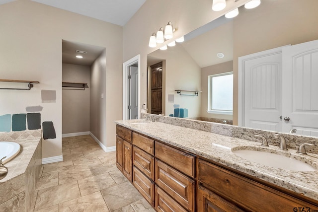 bathroom with vanity and tiled bath