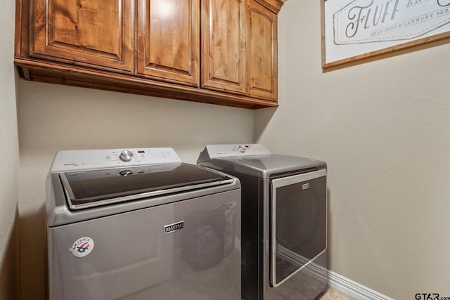 laundry room with cabinets and washer and clothes dryer