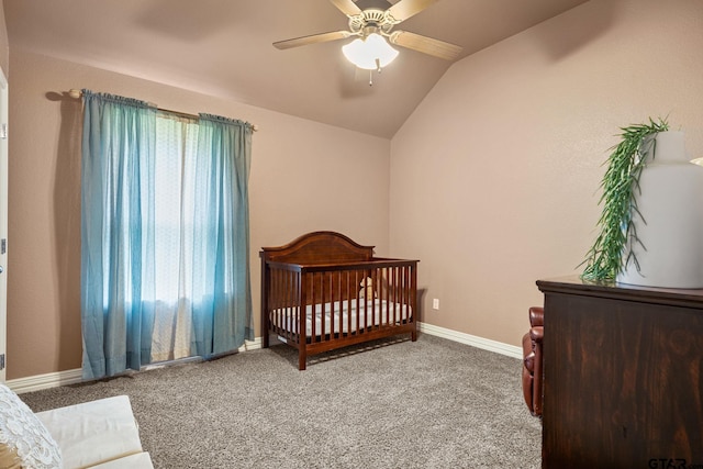 carpeted bedroom featuring lofted ceiling, a nursery area, and ceiling fan