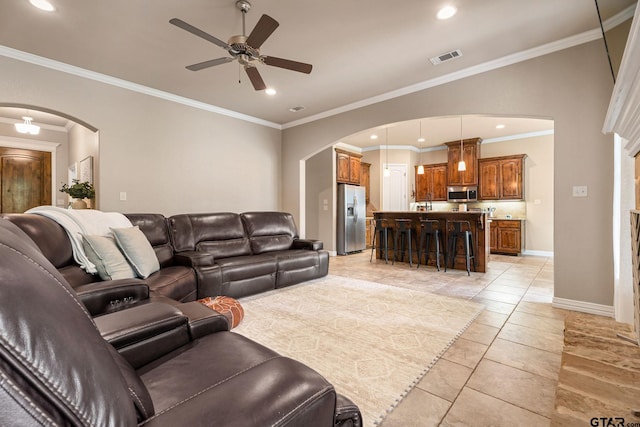 living room featuring crown molding, ceiling fan, and light tile patterned flooring