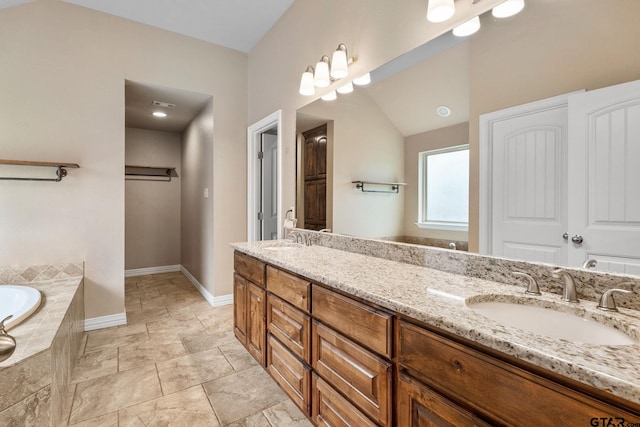 bathroom with vanity and tiled tub