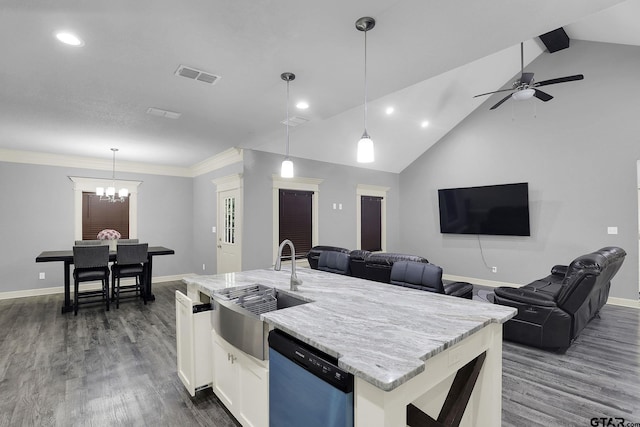 kitchen with a kitchen island with sink, white cabinets, vaulted ceiling, stainless steel dishwasher, and decorative light fixtures