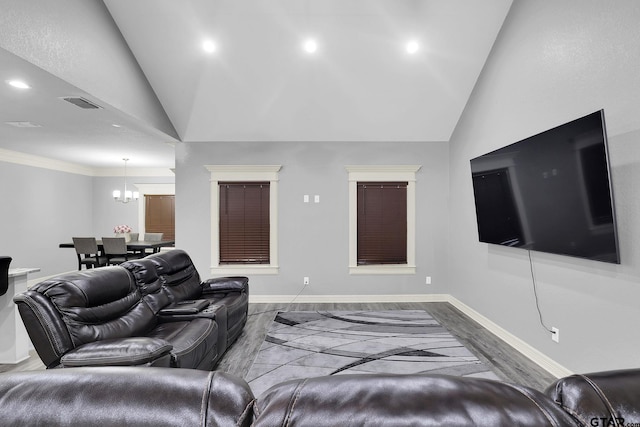 living room with a chandelier, hardwood / wood-style floors, and lofted ceiling