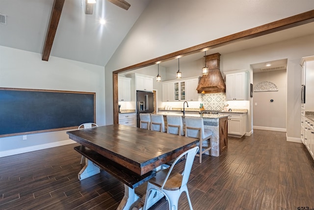 dining area featuring visible vents, beamed ceiling, baseboards, a ceiling fan, and dark wood finished floors