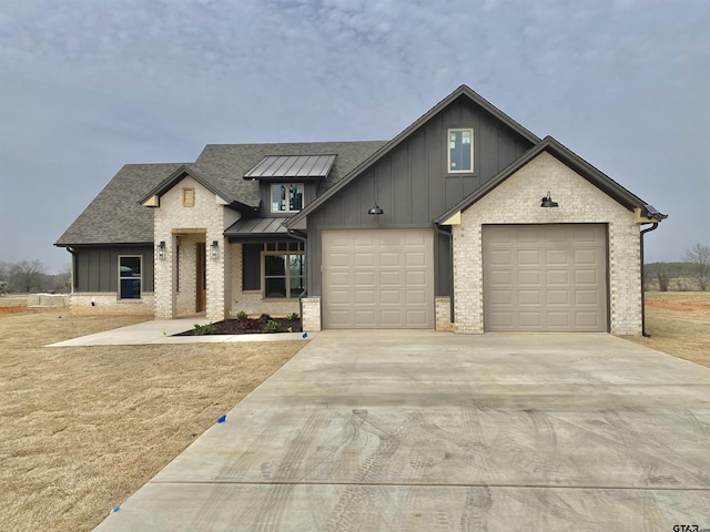 view of front of home with metal roof, board and batten siding, driveway, and a standing seam roof