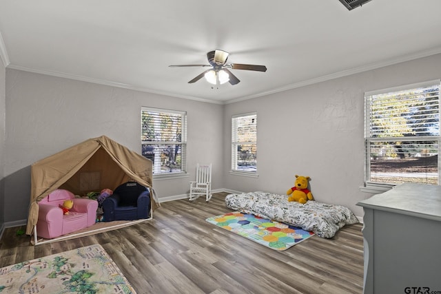 bedroom with dark wood-type flooring, ceiling fan, and crown molding