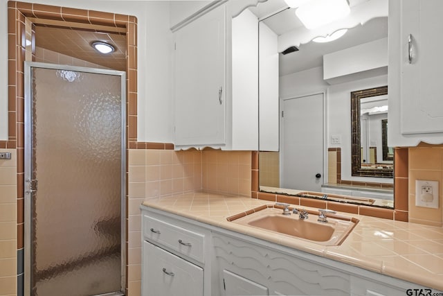 bathroom featuring vanity, backsplash, and walk in shower