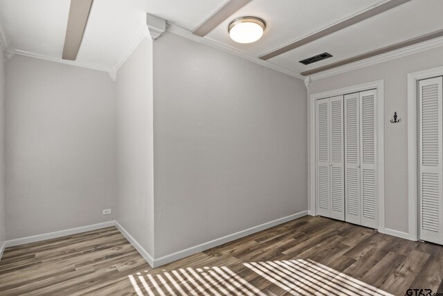 unfurnished bedroom featuring hardwood / wood-style flooring, ornamental molding, and a closet