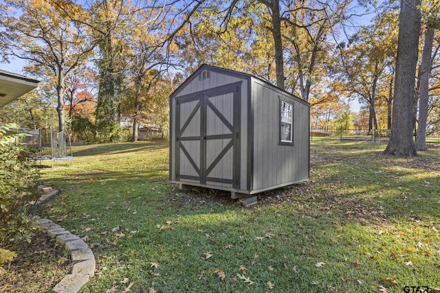 view of outdoor structure with a trampoline and a lawn