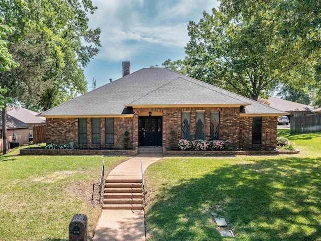 6109 Stoneleigh Dr, Tyler, TX 75703 - view of front of house featuring a shingled roof, a front lawn, a chimney, and brick siding