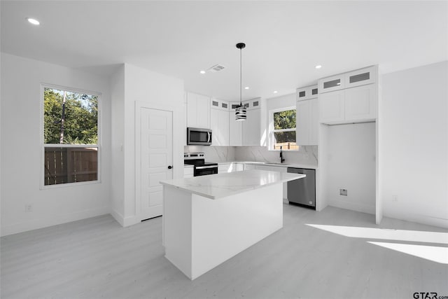 kitchen with white cabinetry, pendant lighting, appliances with stainless steel finishes, and a center island