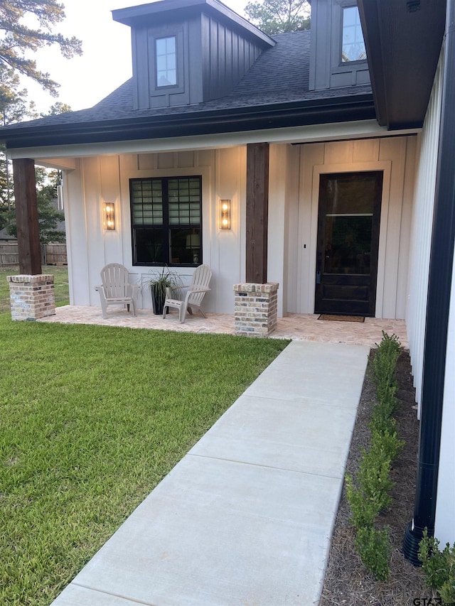 entrance to property featuring a yard and a porch