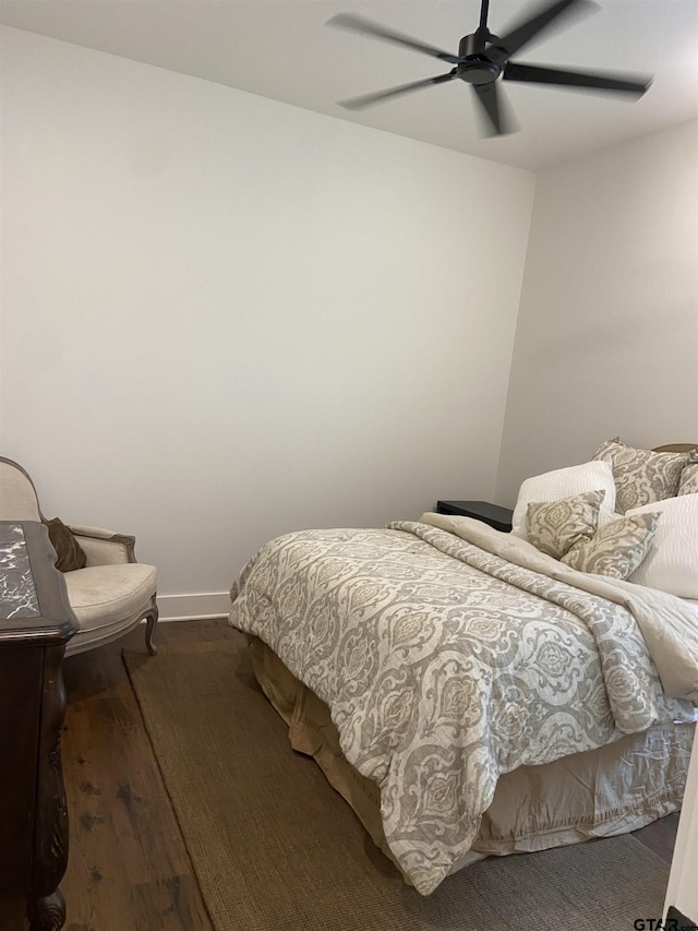 bedroom with dark hardwood / wood-style flooring and ceiling fan