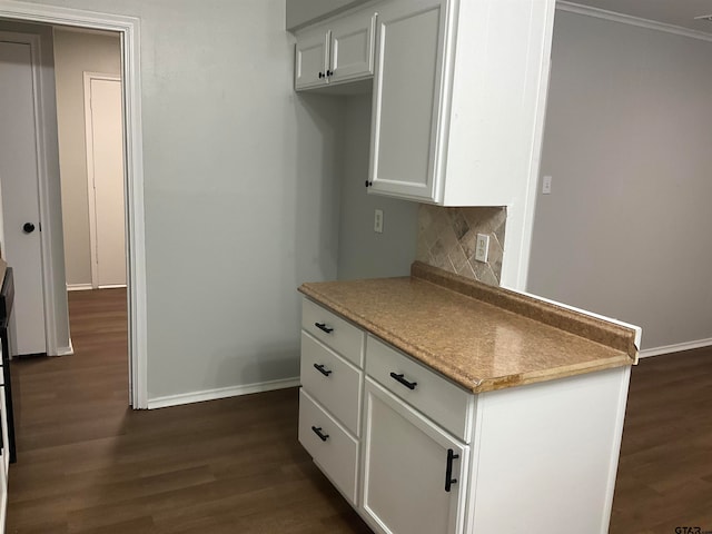 kitchen with white cabinets, ornamental molding, dark hardwood / wood-style floors, and backsplash