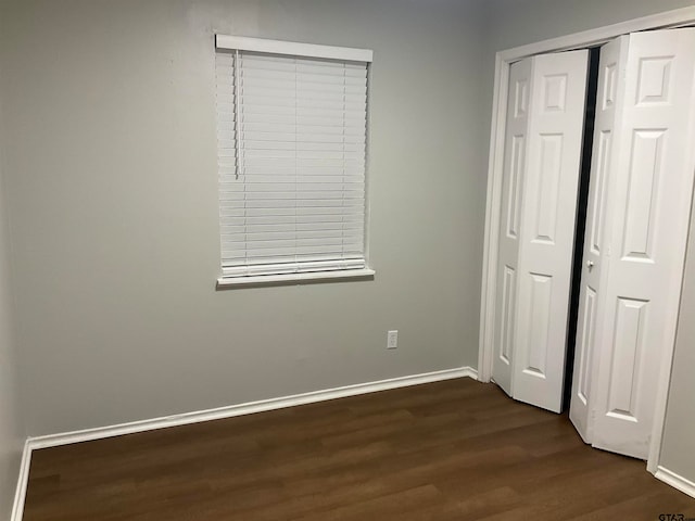 unfurnished bedroom with dark hardwood / wood-style floors