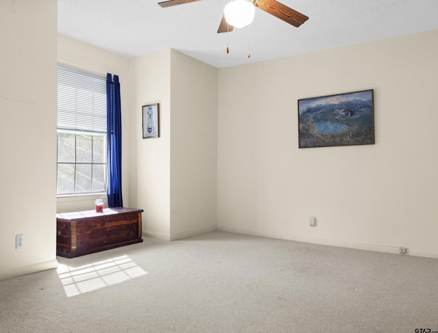 unfurnished room with light colored carpet and ceiling fan