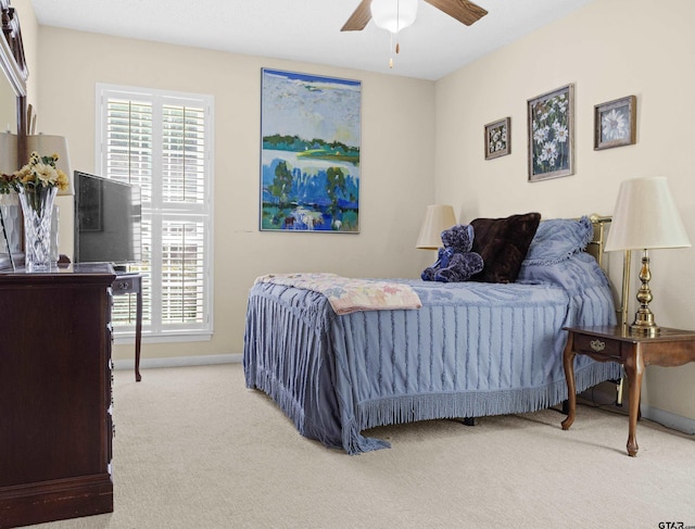 bedroom featuring multiple windows, ceiling fan, and light carpet