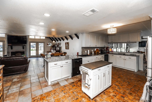 kitchen with white cabinets, kitchen peninsula, dishwasher, and a kitchen island