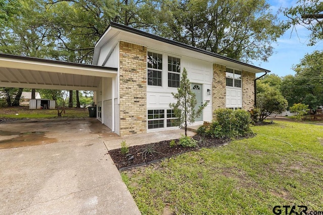 2442 E Devine, Tyler, TX 75701 - view of front of property featuring a front lawn, driveway, brick siding, and an attached carport
