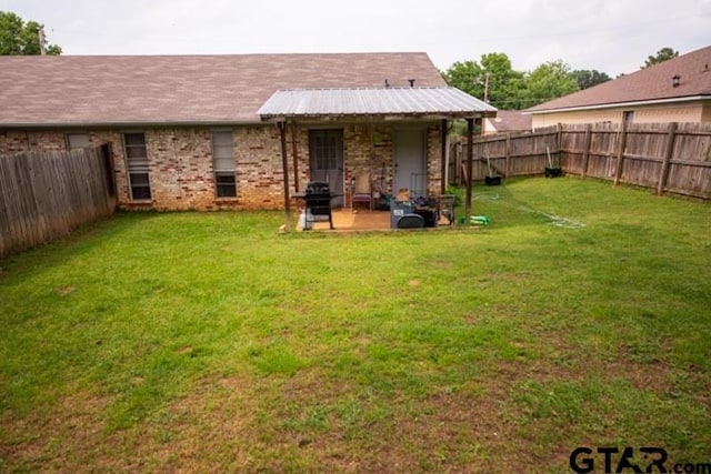 304 Blake Dr, Longview, TX 75604 - back of property with a fenced backyard, brick siding, and a patio area
