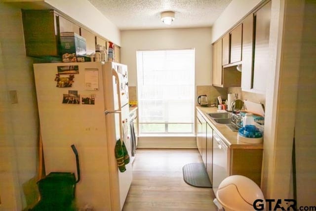 304 Blake Dr, Longview, TX 75604 - kitchen with white appliances, a textured ceiling, light countertops, and light wood-type flooring