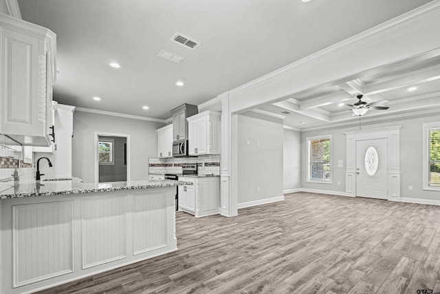 kitchen with light hardwood / wood-style flooring, light stone countertops, crown molding, and white cabinets