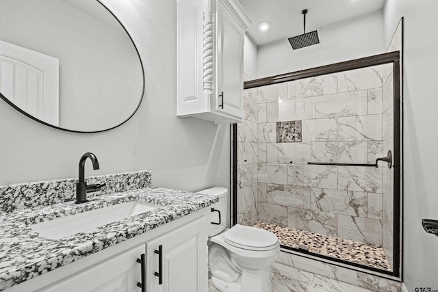 bathroom with toilet, vanity, and a tile shower