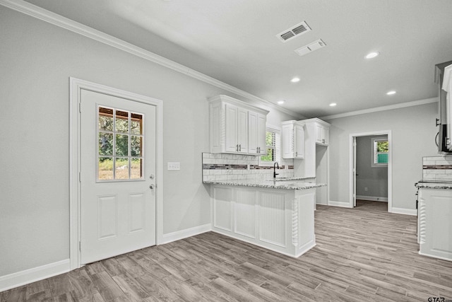 kitchen with white cabinets, light wood-type flooring, and plenty of natural light