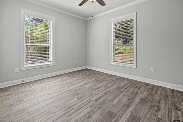 empty room featuring ceiling fan, plenty of natural light, light wood-type flooring, and crown molding