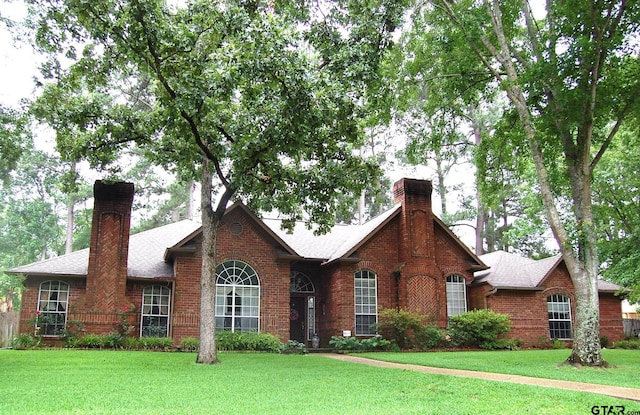 1683 Old Oak Dr, Tyler, TX 75703 - view of front facade featuring a chimney, brick siding, and a front lawn