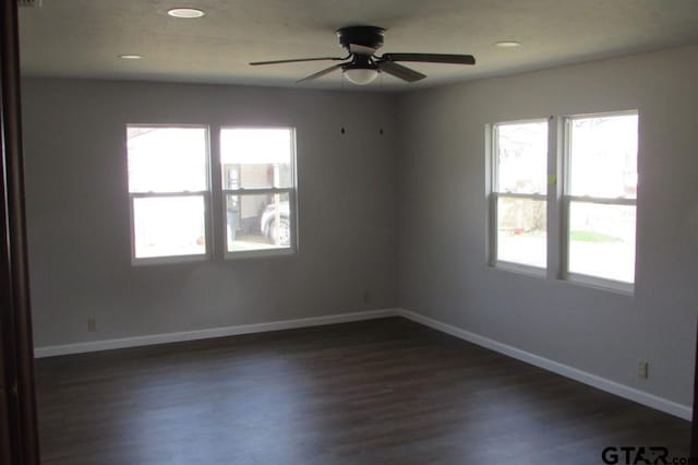 unfurnished room featuring recessed lighting, dark wood-style flooring, a healthy amount of sunlight, and baseboards