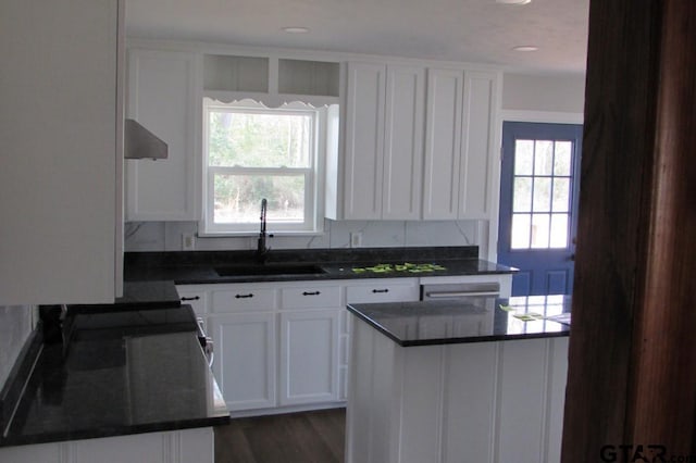 kitchen featuring dark countertops, white cabinetry, and a sink