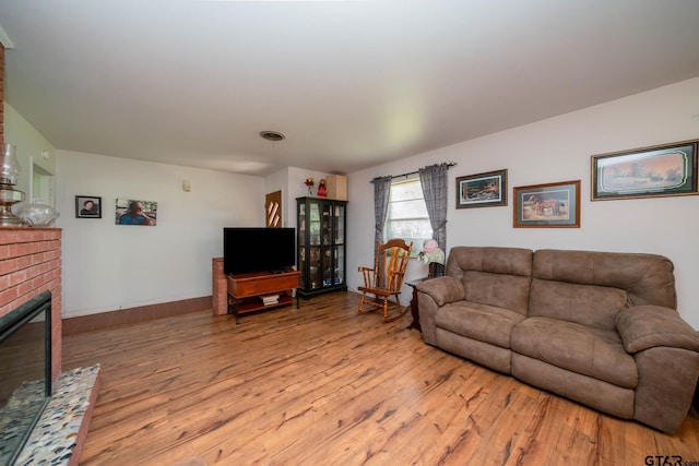 126 Jordan, Rusk, TX 75785 - living room with wood finished floors and a brick fireplace