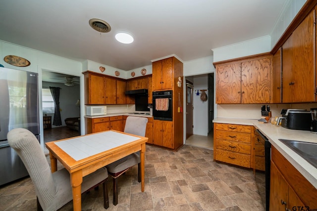 126 Jordan, Rusk, TX 75785 - kitchen featuring black appliances, stone finish floors, brown cabinets, under cabinet range hood, and a ceiling fan