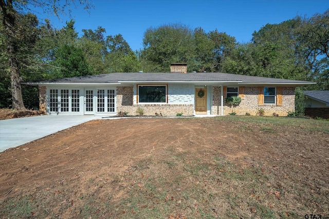2014 Miller Dr, Tyler, TX 75701 - ranch-style house featuring french doors, a chimney, and brick siding