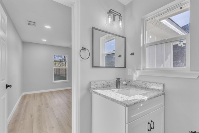 bathroom with recessed lighting, wood finished floors, vanity, visible vents, and baseboards