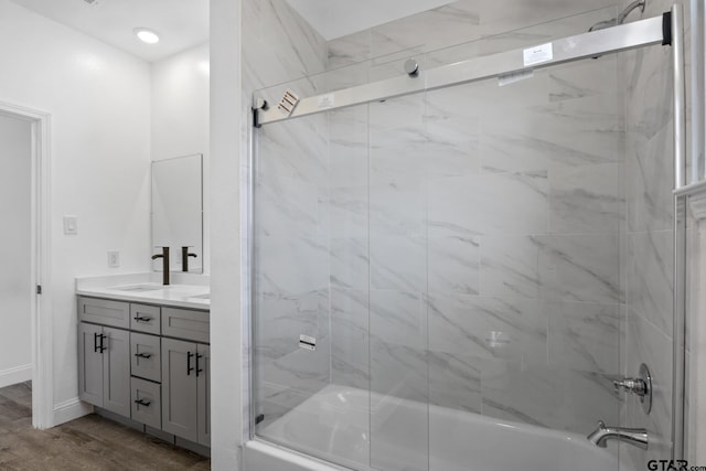 bathroom featuring hardwood / wood-style floors, vanity, and combined bath / shower with glass door