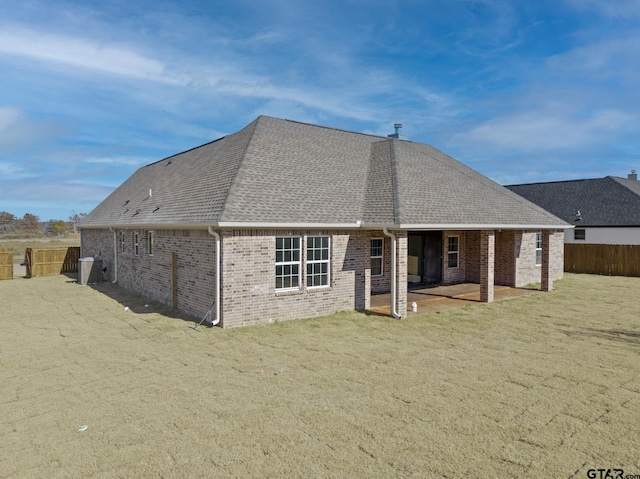 rear view of property with central AC unit, a yard, and a patio