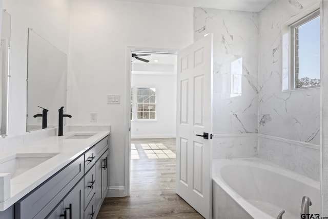 bathroom with hardwood / wood-style flooring, ceiling fan, a healthy amount of sunlight, and vanity