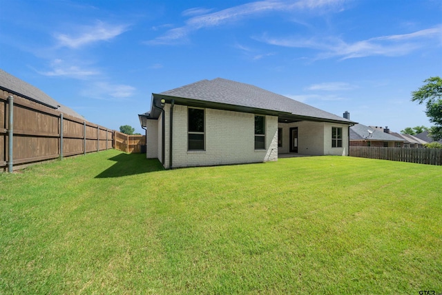 1838 Rocky Mtn, Tyler, TX 75703 - rear view of house featuring a fenced backyard, brick siding, and roof with shingles