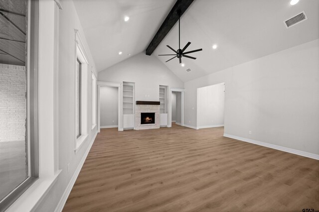1838 Rocky Mtn, Tyler, TX 75703 - unfurnished living room featuring beam ceiling, a ceiling fan, a warm lit fireplace, light wood finished floors, and built in shelves