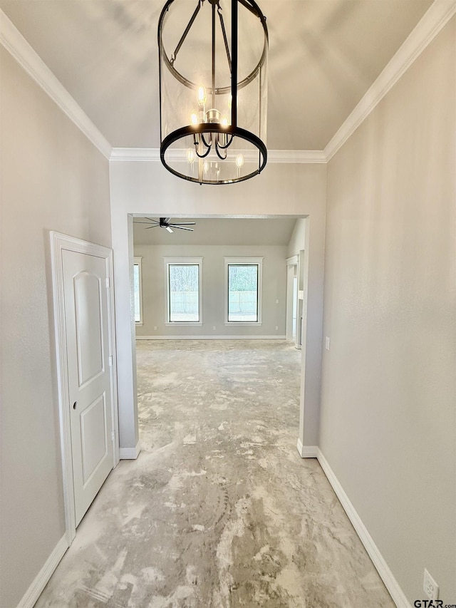 hallway with an inviting chandelier, unfinished concrete flooring, baseboards, and ornamental molding