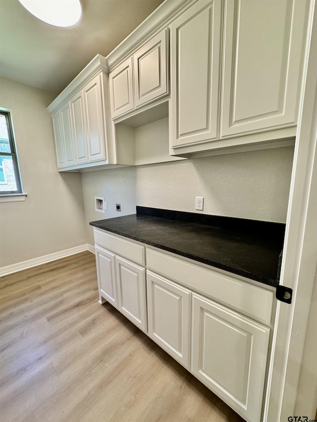 laundry room with cabinet space, electric dryer hookup, washer hookup, baseboards, and light wood-style floors