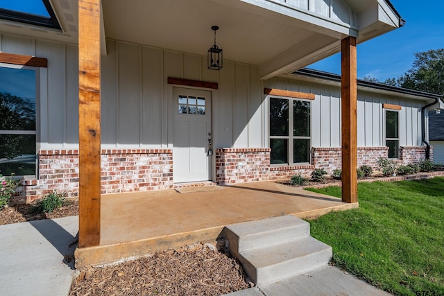 property entrance featuring a lawn