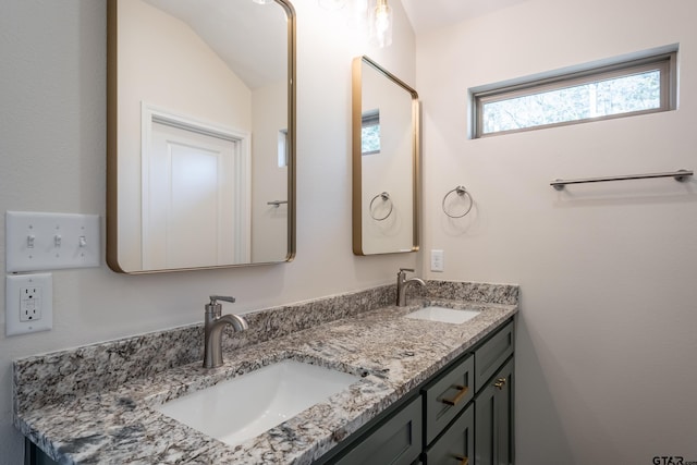 bathroom featuring vanity and lofted ceiling